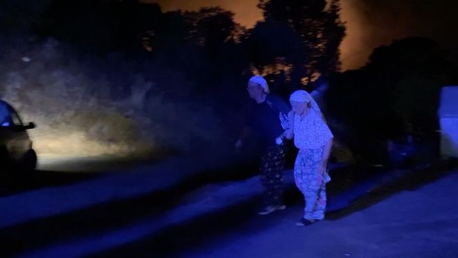 Gece saatlerinde yangın bölgesinden uzaklaştırılan vatandaşlar.