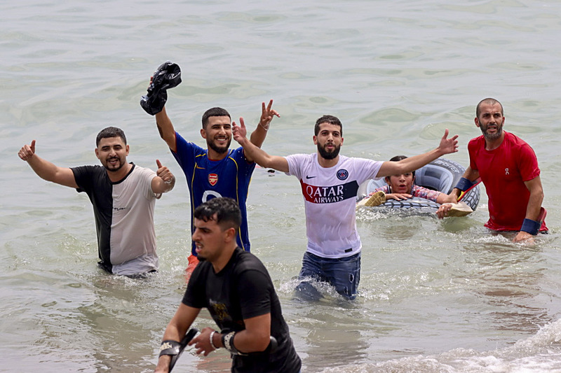 Sığ suda yürüyen ve kıyıya yaklaşan kişiler.