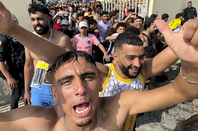 Ceuta sınır hattı yakınında kalabalık içinde ilerleyen kişiler.