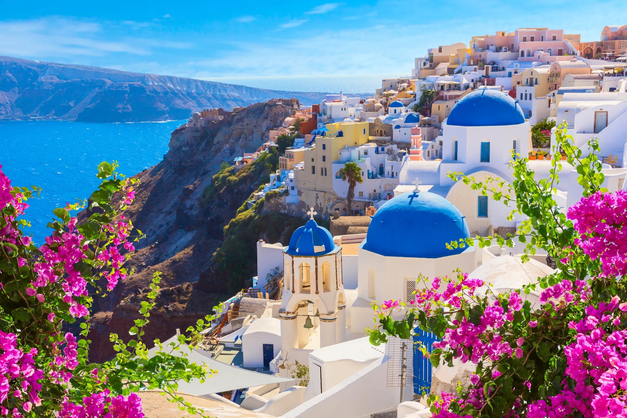 Santorini’de beyaz yapılar, mavi kubbeler ve Ege Denizi manzarası.