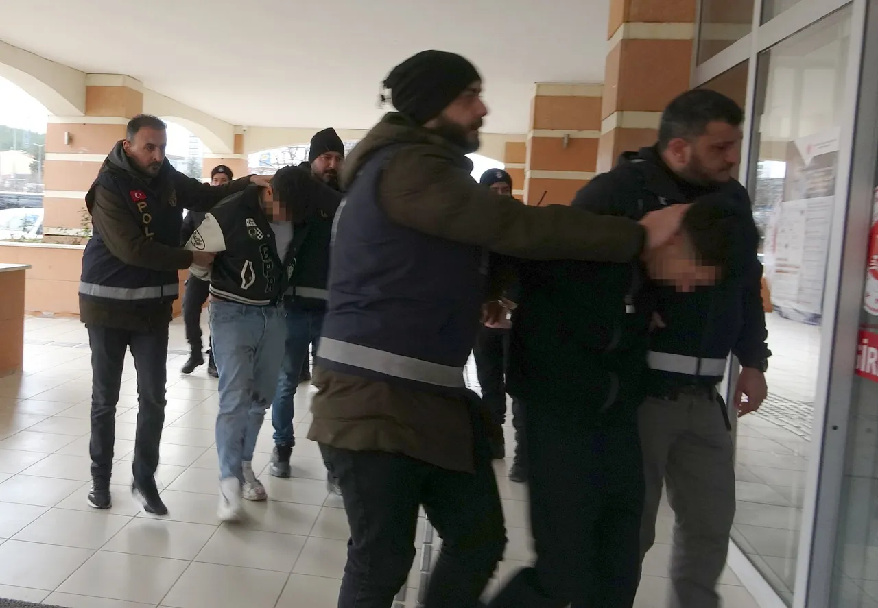 Polis ekiplerinin adliye girişinde şüphelileri götürdüğü görüntü.