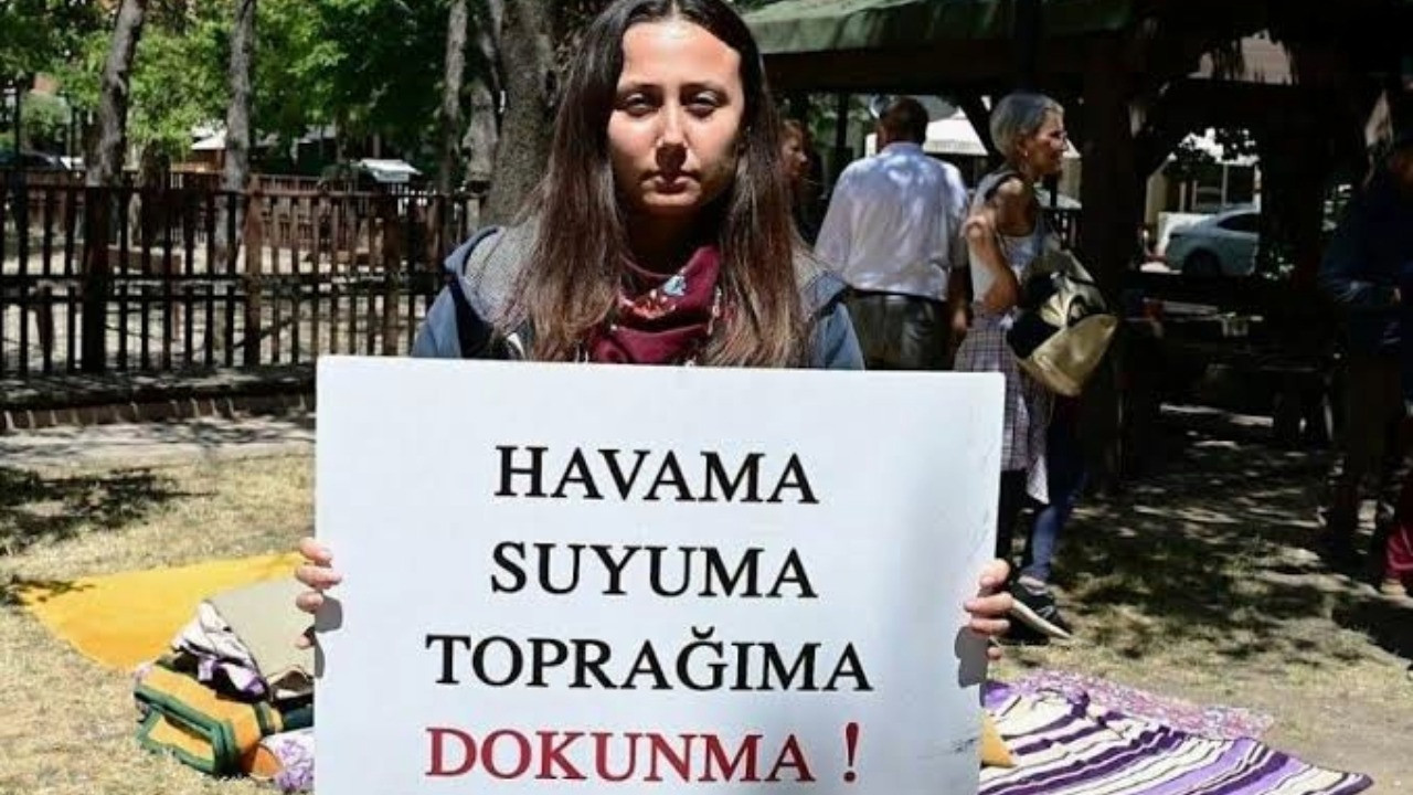 Esra Işık, üzerinde çevre talebi yazılı pankartla görülüyor.