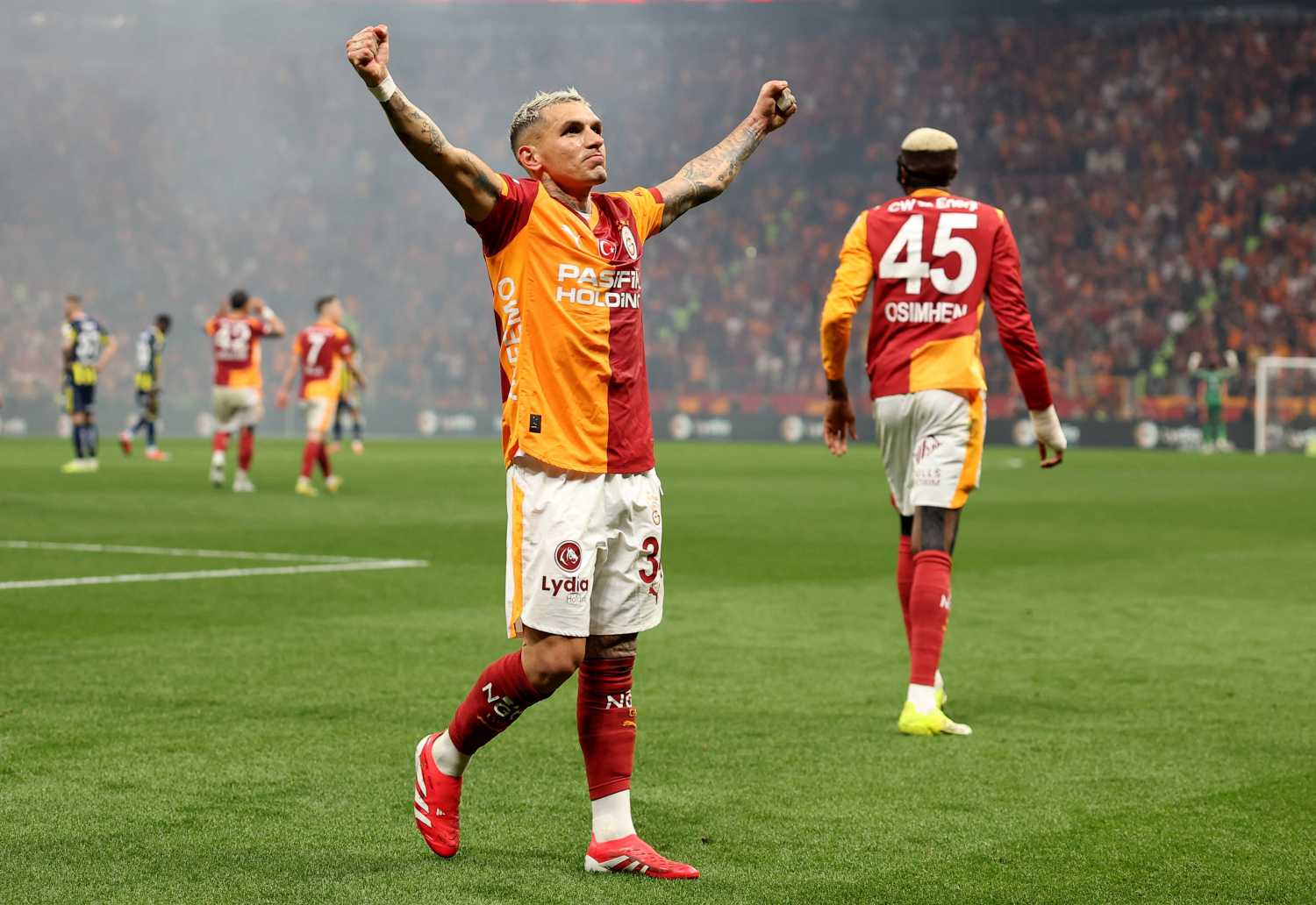 Lucas Torreira sahada iki kolunu kaldırarak taraftarı selamlıyor.