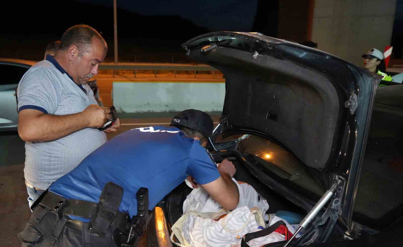 Polis ekiplerinin durdurulan bir aracın bagajında arama yapması.