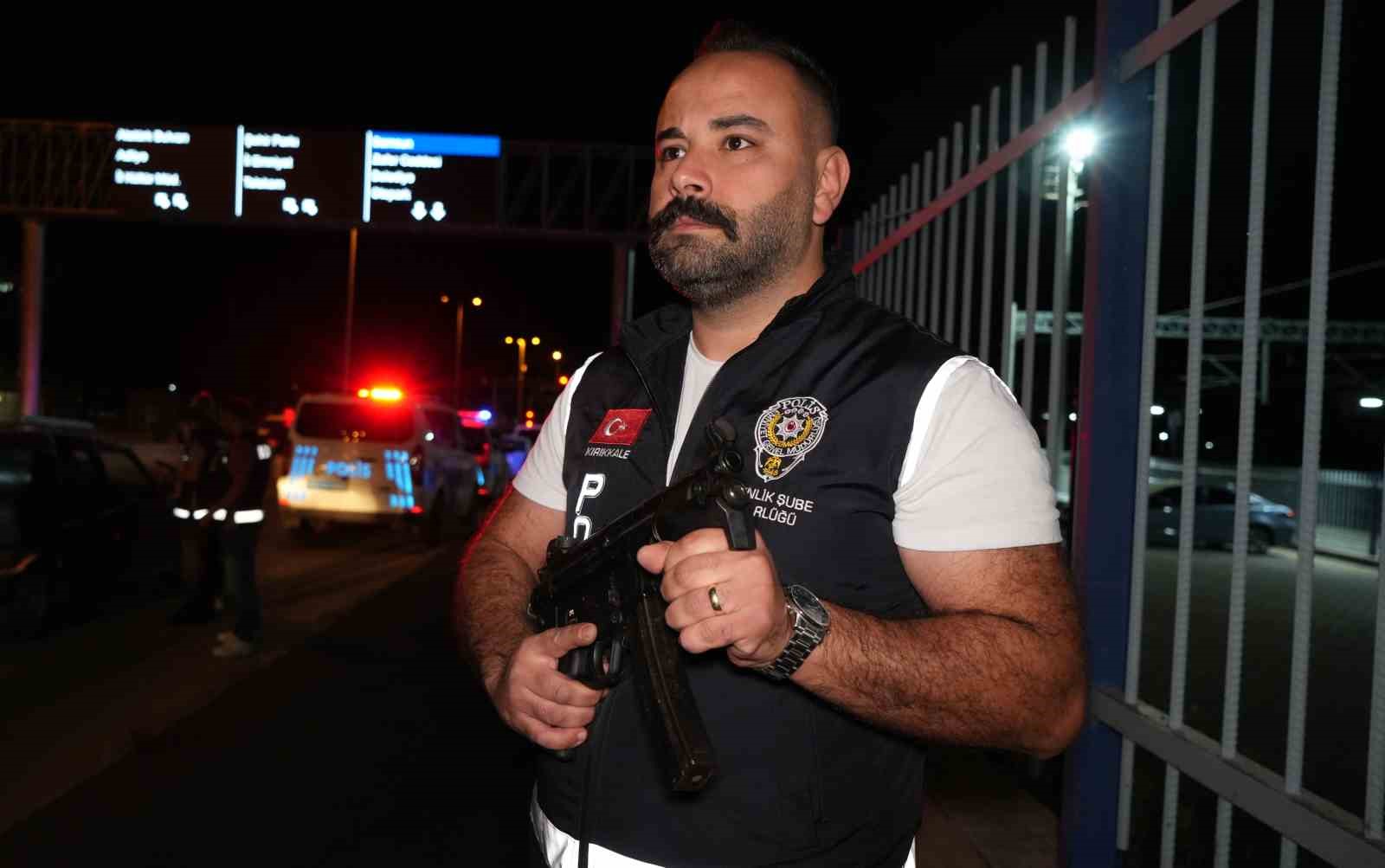 Gece uygulama noktasında görev yapan silahlı polis memuru.