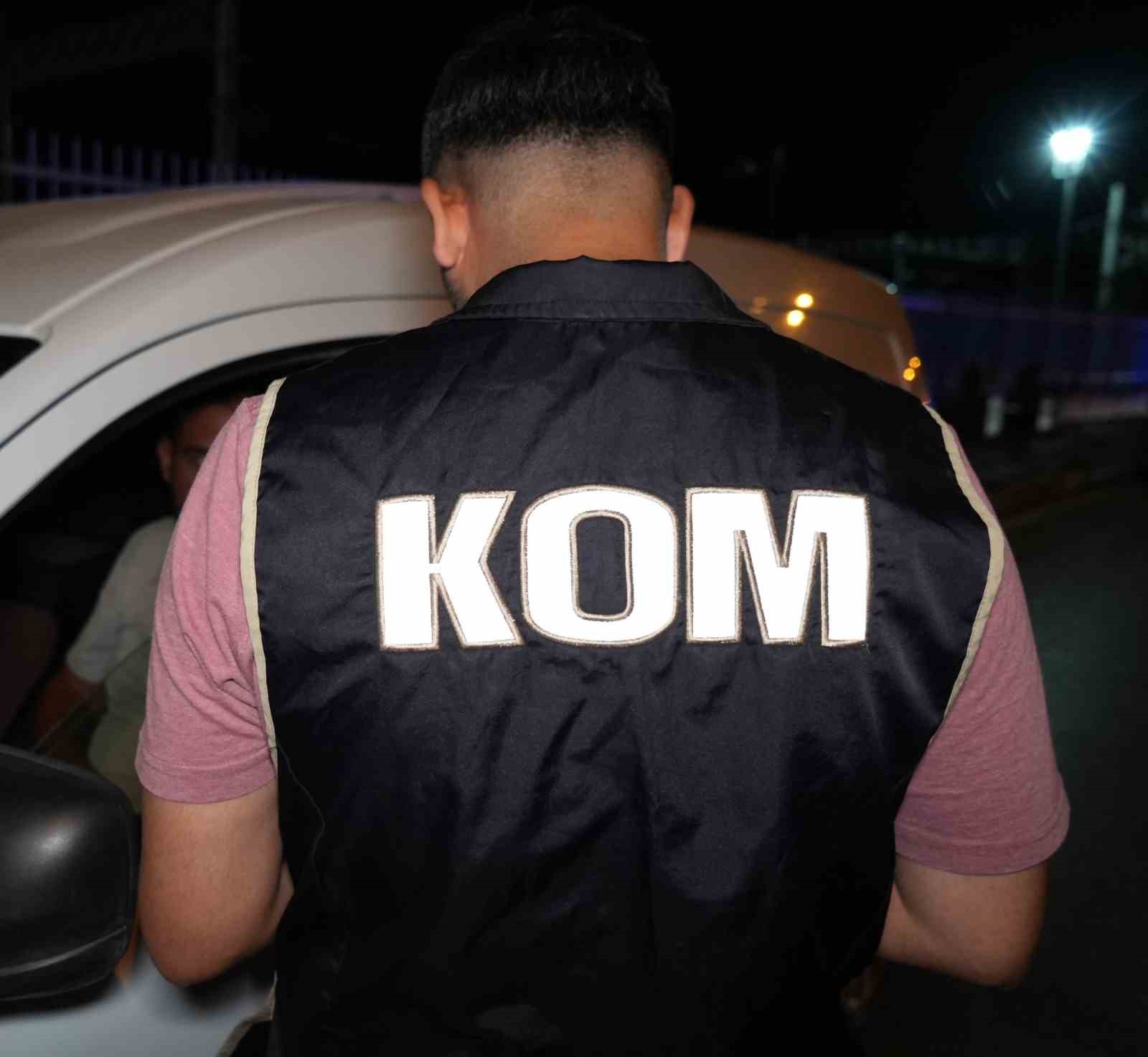 KOM yeleği giyen polisin durdurulan araç yanında kontrol yapması.
