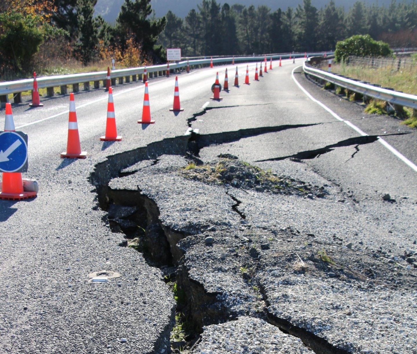 Deprem nedeniyle yarılmış bir yol ve güvenlik konileri.