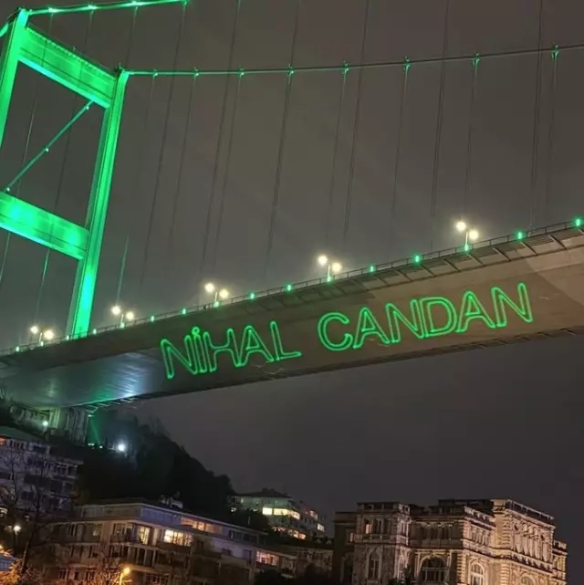 15 Temmuz Şehitler Köprüsü üzerinde yeşil lazerle yazılmış “NİHAL CANDAN” yazısı.
