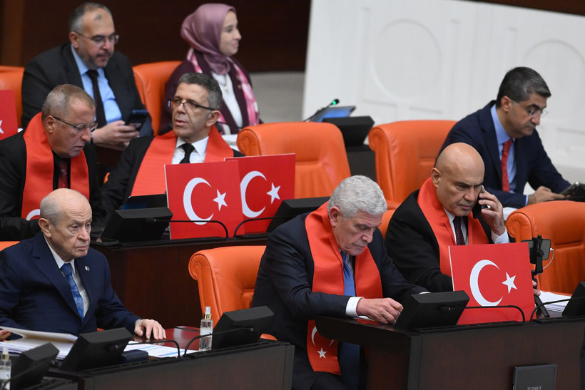 TBMM Genel Kurulu'nda Türk bayrakları ve bayraklı atkılarla oturan İYİ Partili milletvekilleri.