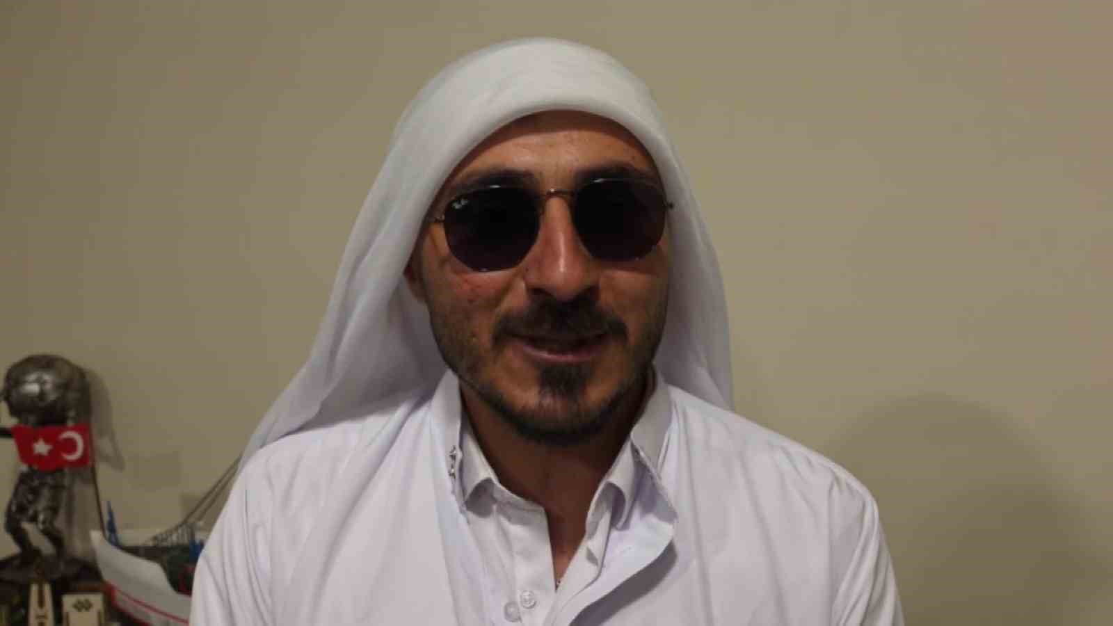Beyaz kıyafet ve güneş gözlüğü takan Sefa Koç kameraya açıklama yapıyor.