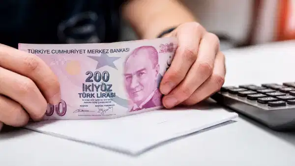 Bir kişinin 200 TL banknot tuttuğu masa düzeni
