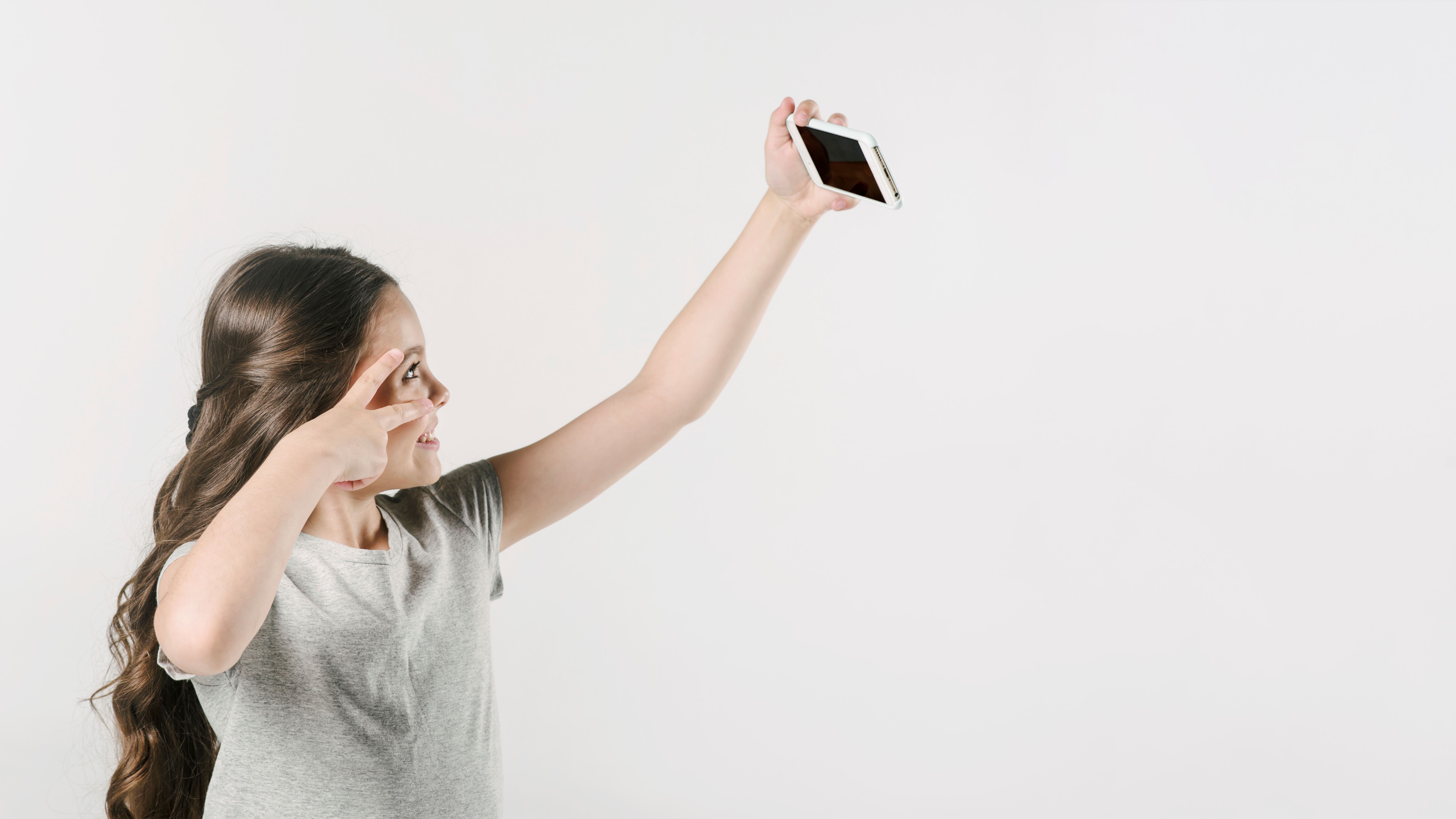 Bir çocuğun cep telefonuyla selfie çektiği görsel.