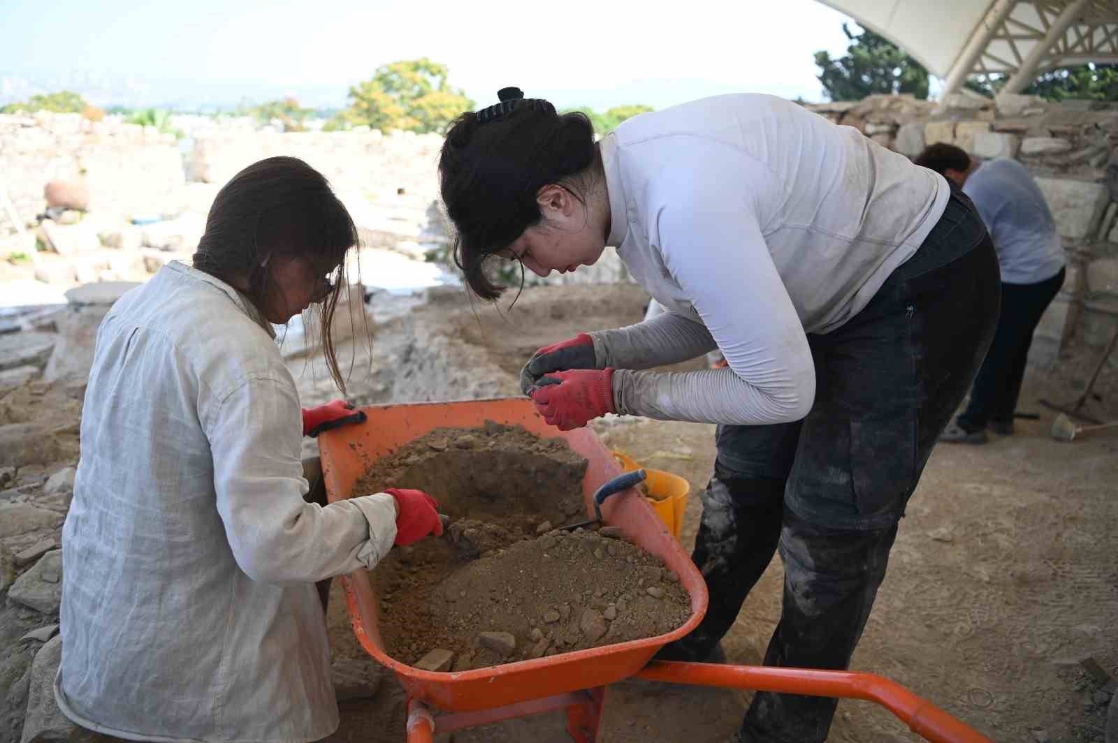Kadıkalesi-Anaia Höyüğü kazı alanında çalışan ekip üyeleri toprak eleme ve buluntu inceleme çalışması yapıyor.