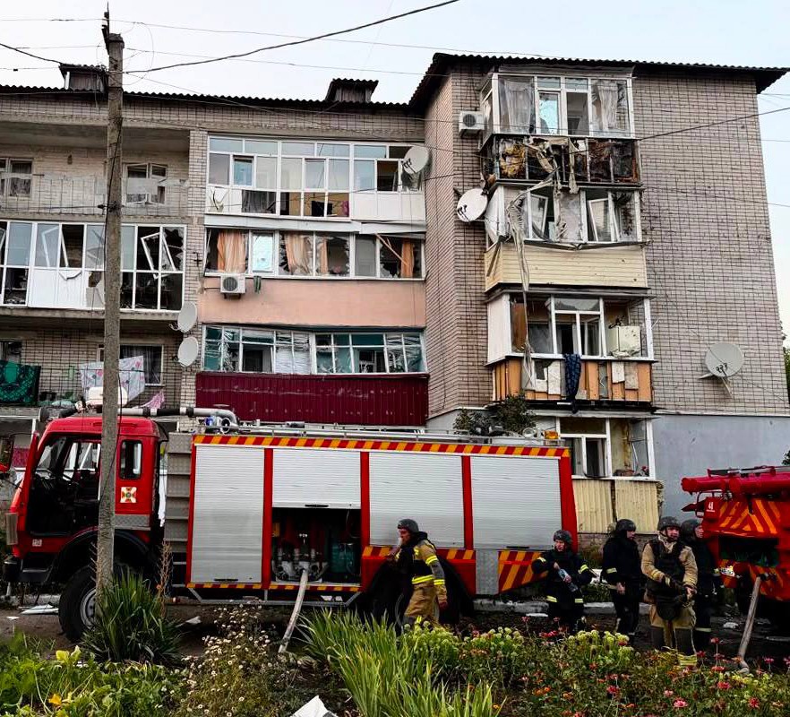 Saldırı sonrası camları kırılan apartman ve çevrede görev yapan itfaiye araçları.