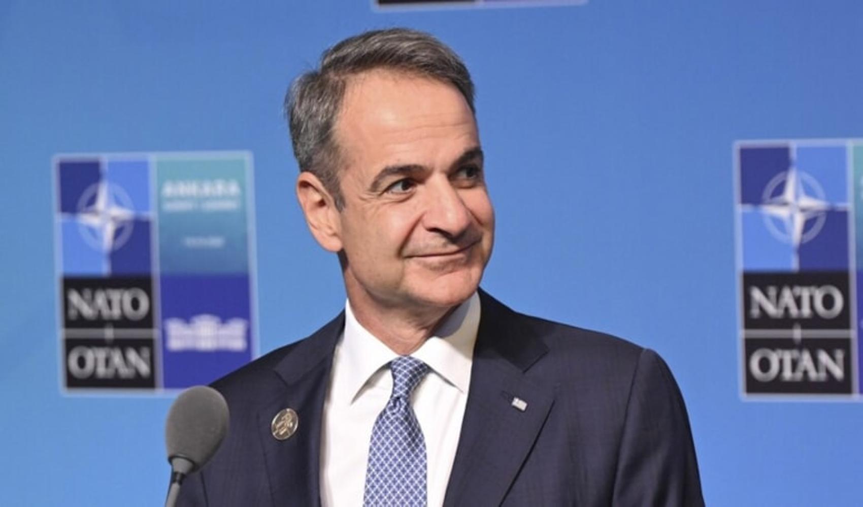 Le Premier ministre grec Kyriakos Mitsotakis photographié devant un arrière-plan de l'OTAN.
