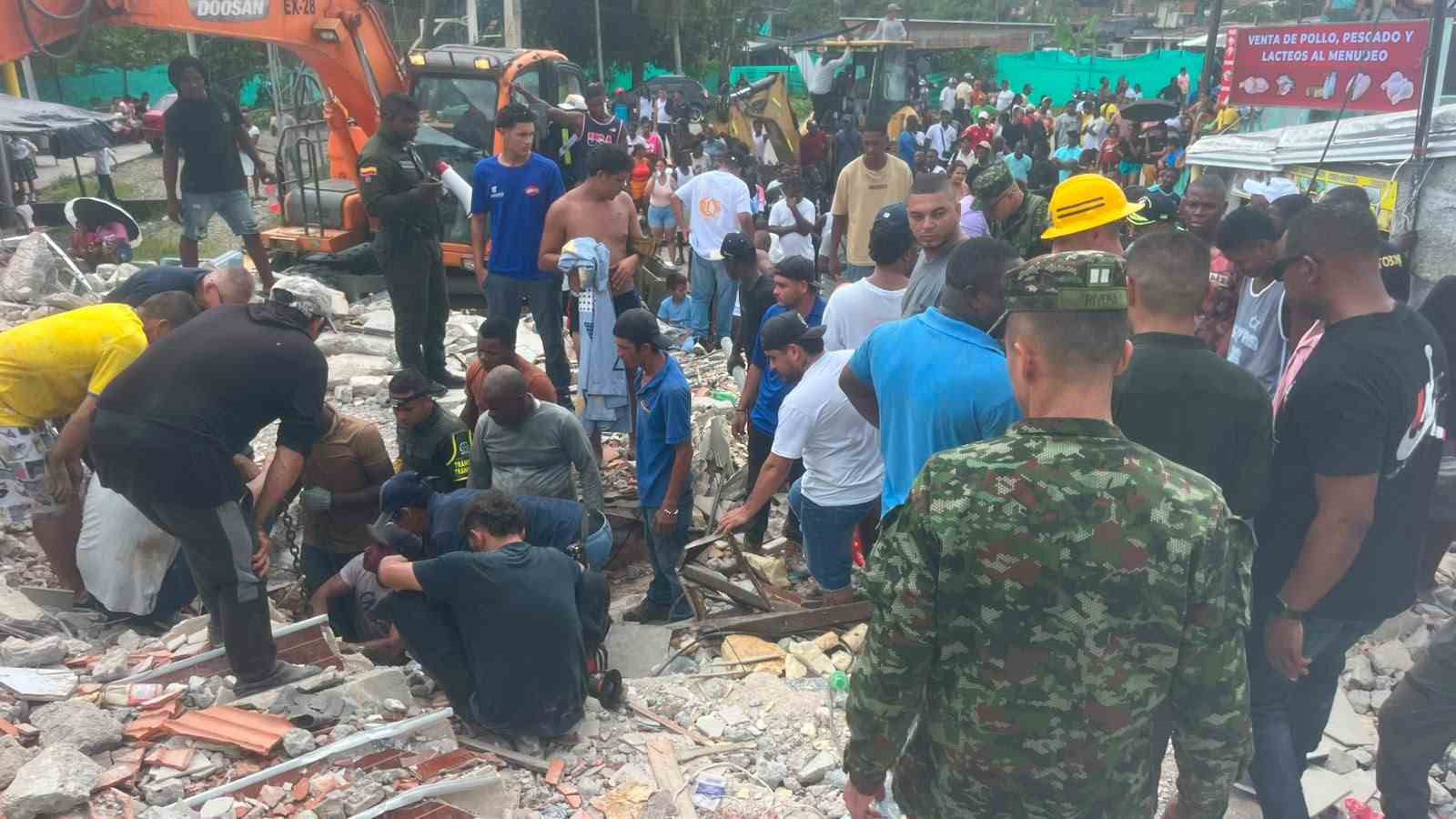 Kolombiya’da deprem sonrası enkaz alanında arama-kurtarma çalışmaları yürüten ekipler ve çevrede toplanan kişiler.