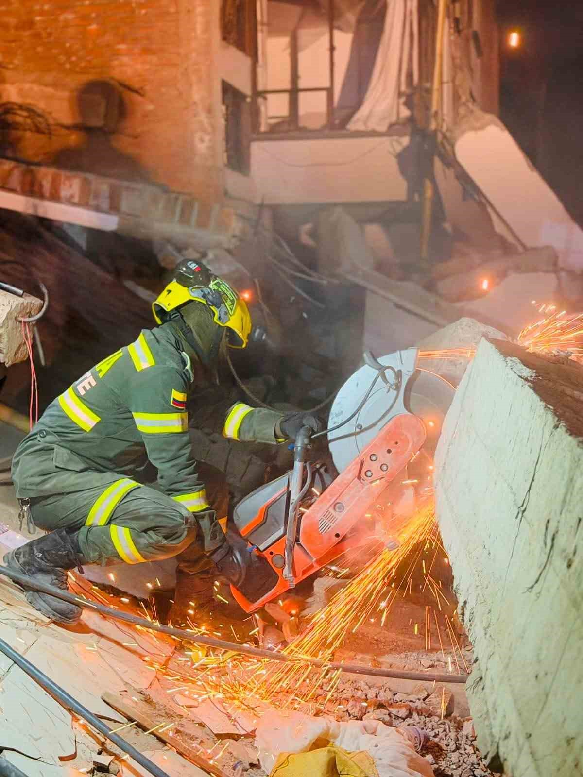 Bir kurtarma görevlisinin enkazda kesici ekipmanla beton ve metal parçaları ayırdığı an.