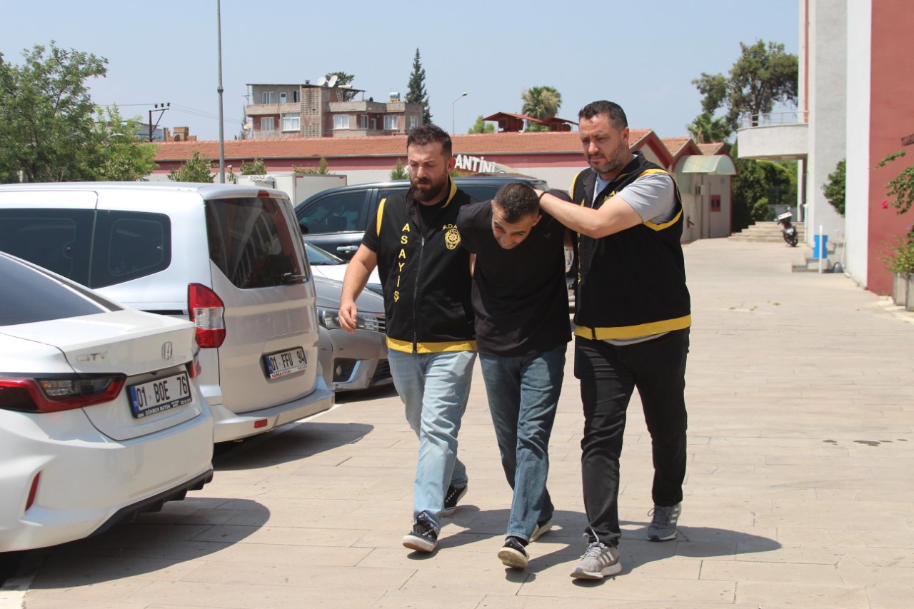 Polis ekiplerinin bir şüpheliyi araçların bulunduğu alanda götürdüğü an görülüyor.
