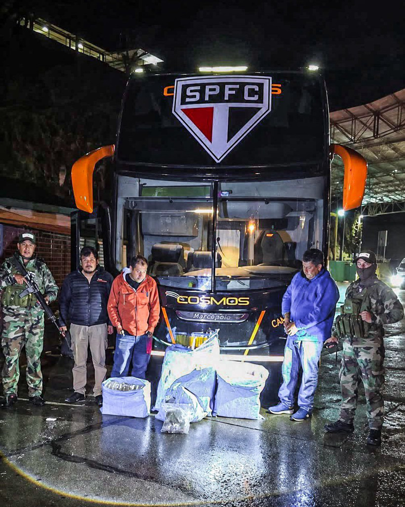 Bolivya’da polislerin önünde duran São Paulo logolu takım otobüsü ve ele geçirilen poşetler.