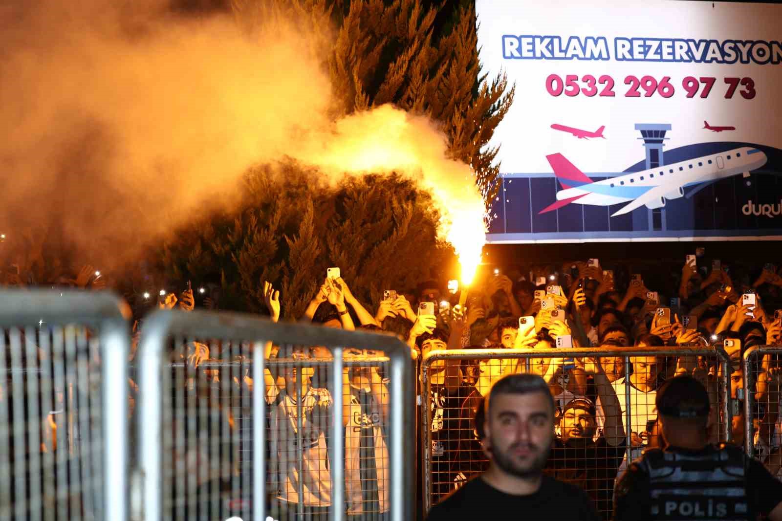 Gece saatlerinde havalimanı dışında meşale yakan Beşiktaş taraftarları görülüyor.
