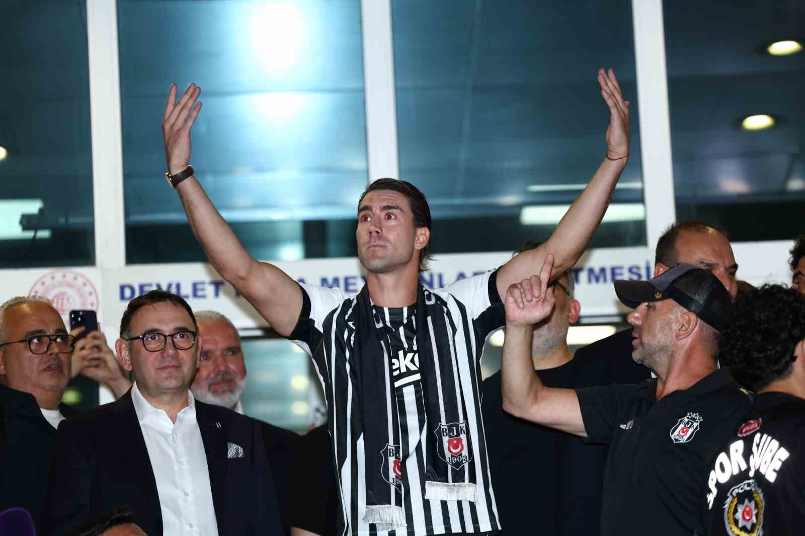 Dusan Vlahovic, Beşiktaş atkısı takmış halde kalabalığa doğru kollarını kaldırıyor.