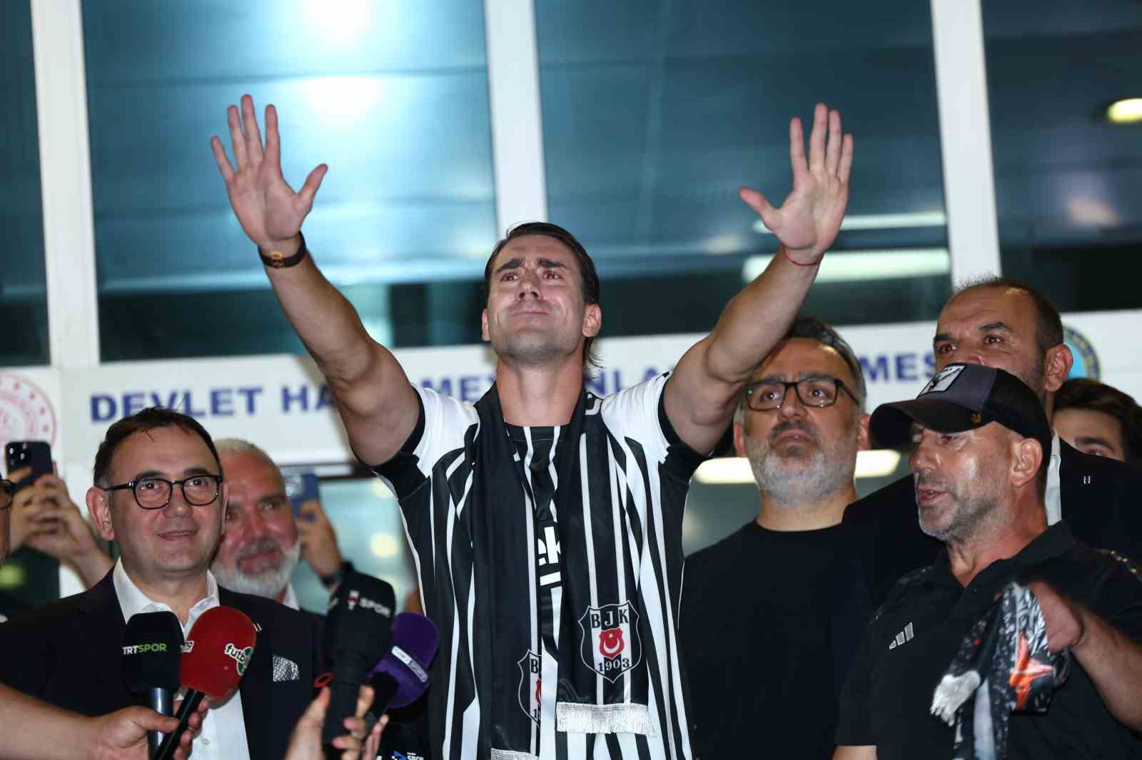 Dusan Vlahovic, havalimanı çıkışında iki elini kaldırarak taraftarları selamlıyor.