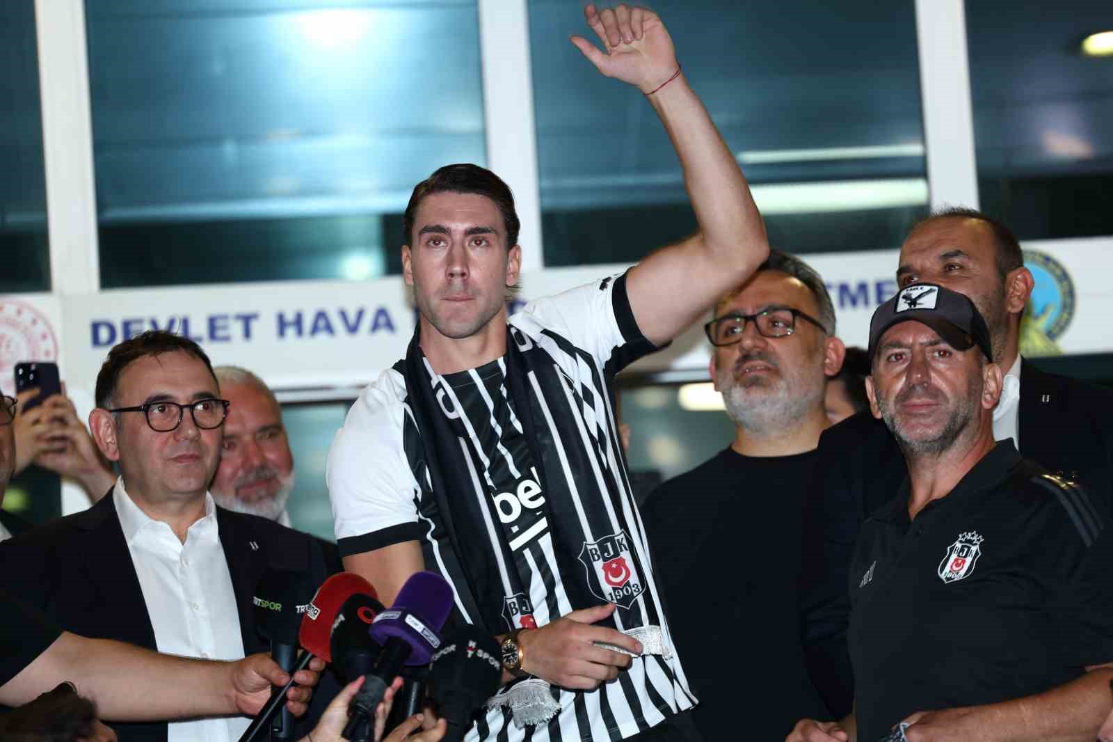 Dusan Vlahovic, Beşiktaş atkısıyla kalabalık arasında elini kaldırıyor.