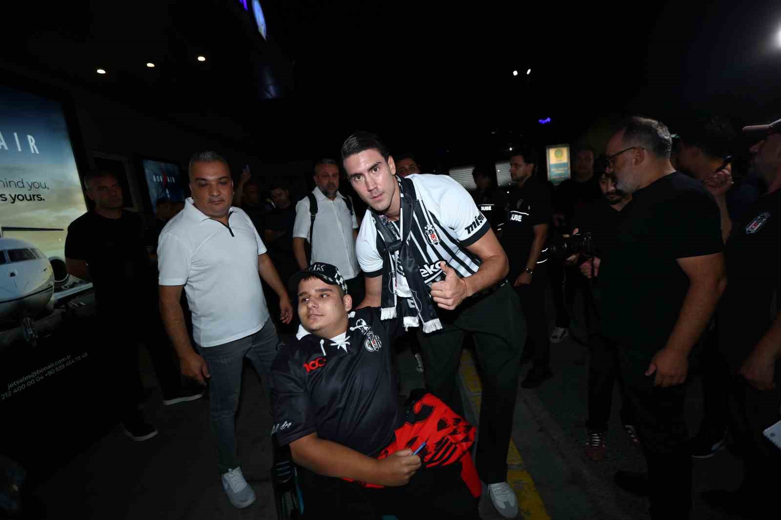 Dusan Vlahovic, havalimanı çıkışında bir Beşiktaş taraftarıyla birlikte poz veriyor.