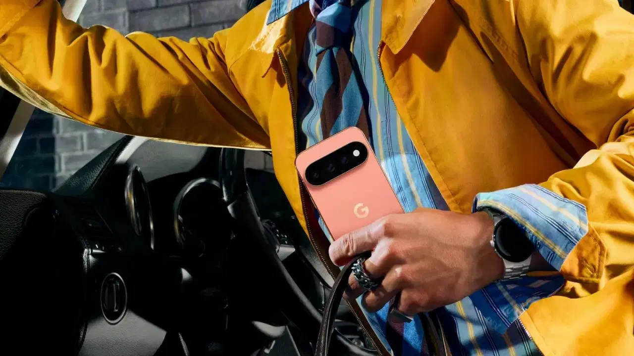 Bir kullanıcının elinde pembe renkli Google Pixel telefon ve bileğinde akıllı saat görülüyor.