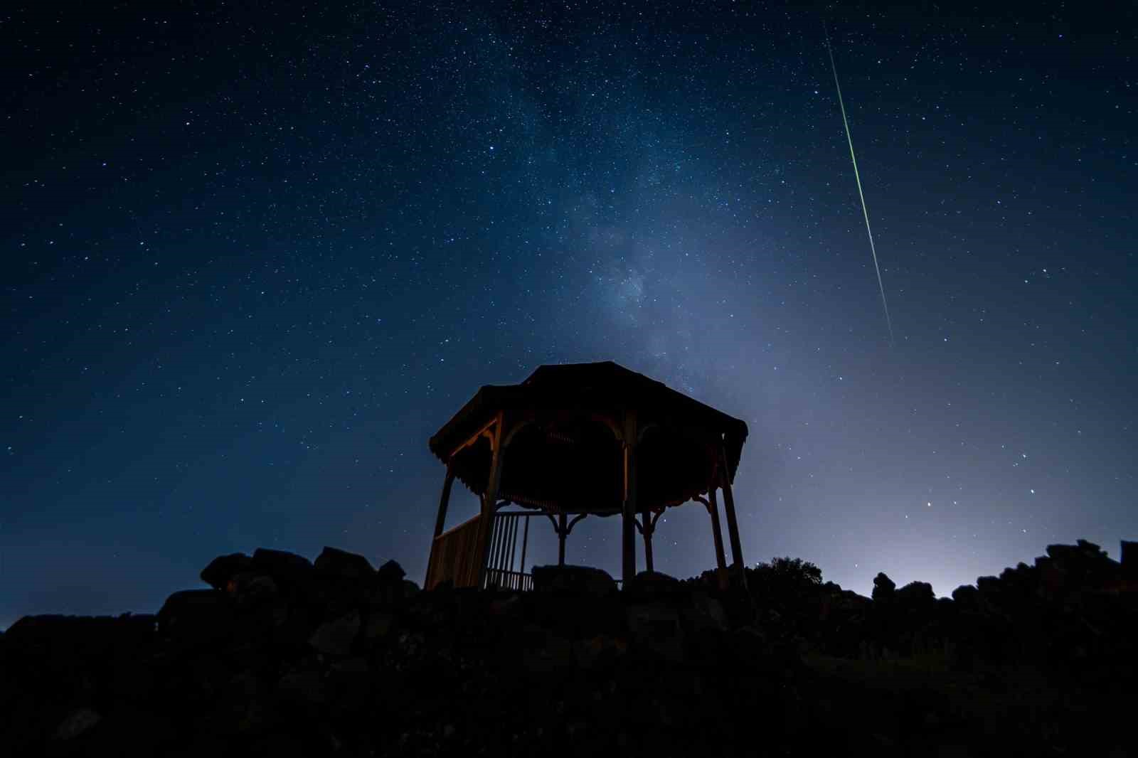 Kula’daki volkanik arazide gece gökyüzünde görülen meteor izi ve yıldızlar.