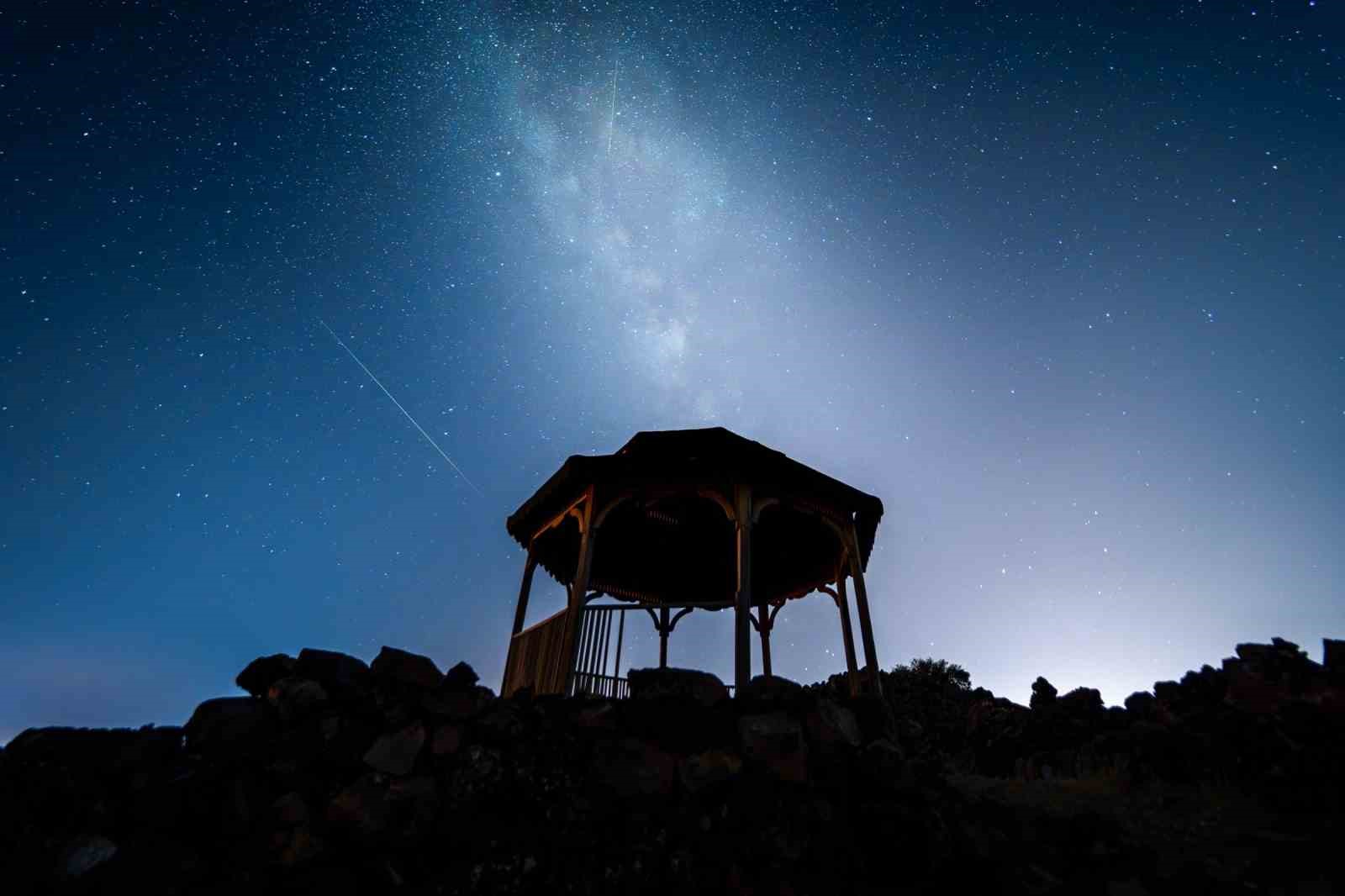 Kula Jeoparkı’nda bir yapının silüeti üzerinde Samanyolu ve meteor izi görülüyor.