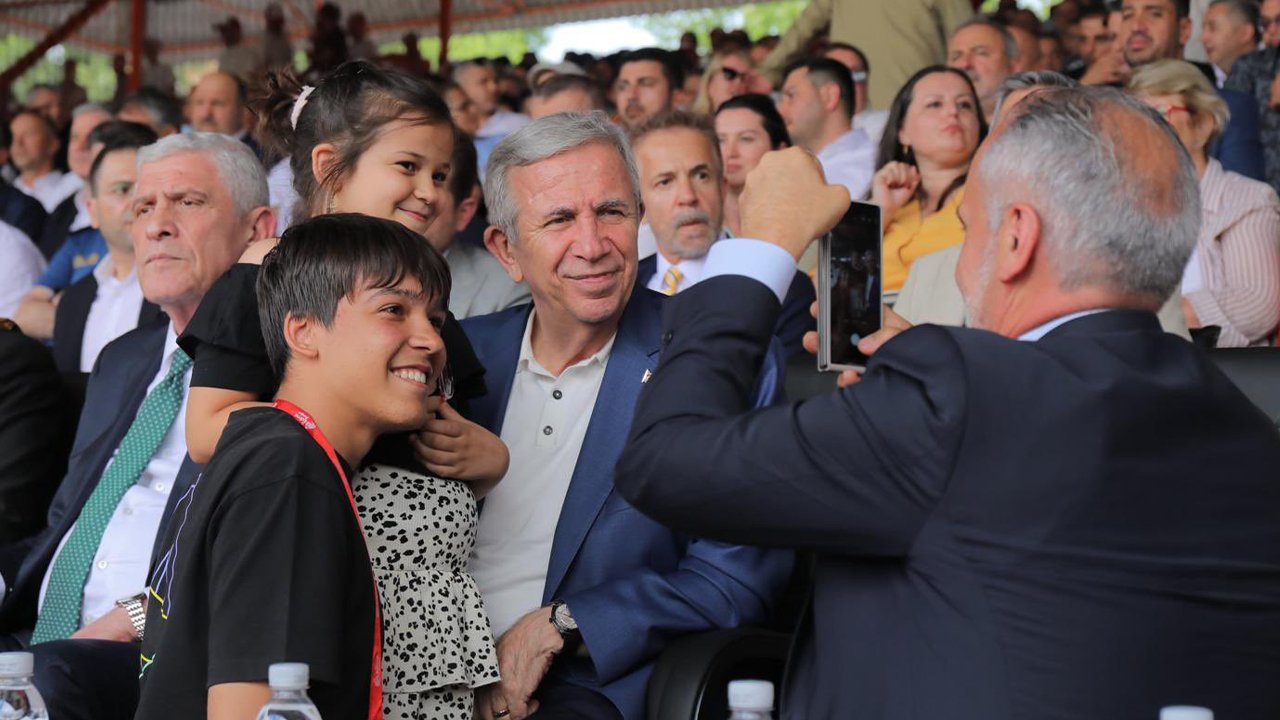 Mansur Yavaş bir etkinlikte vatandaşlarla fotoğraf çektirirken görülüyor.