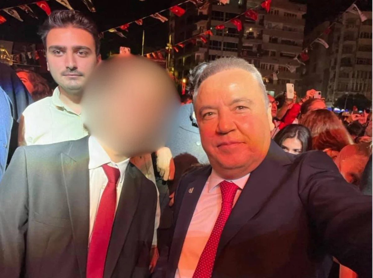 Kalabalık bir etkinlik alanında çekilmiş, bazı yüzleri bulanıklaştırılmış bir fotoğraf.