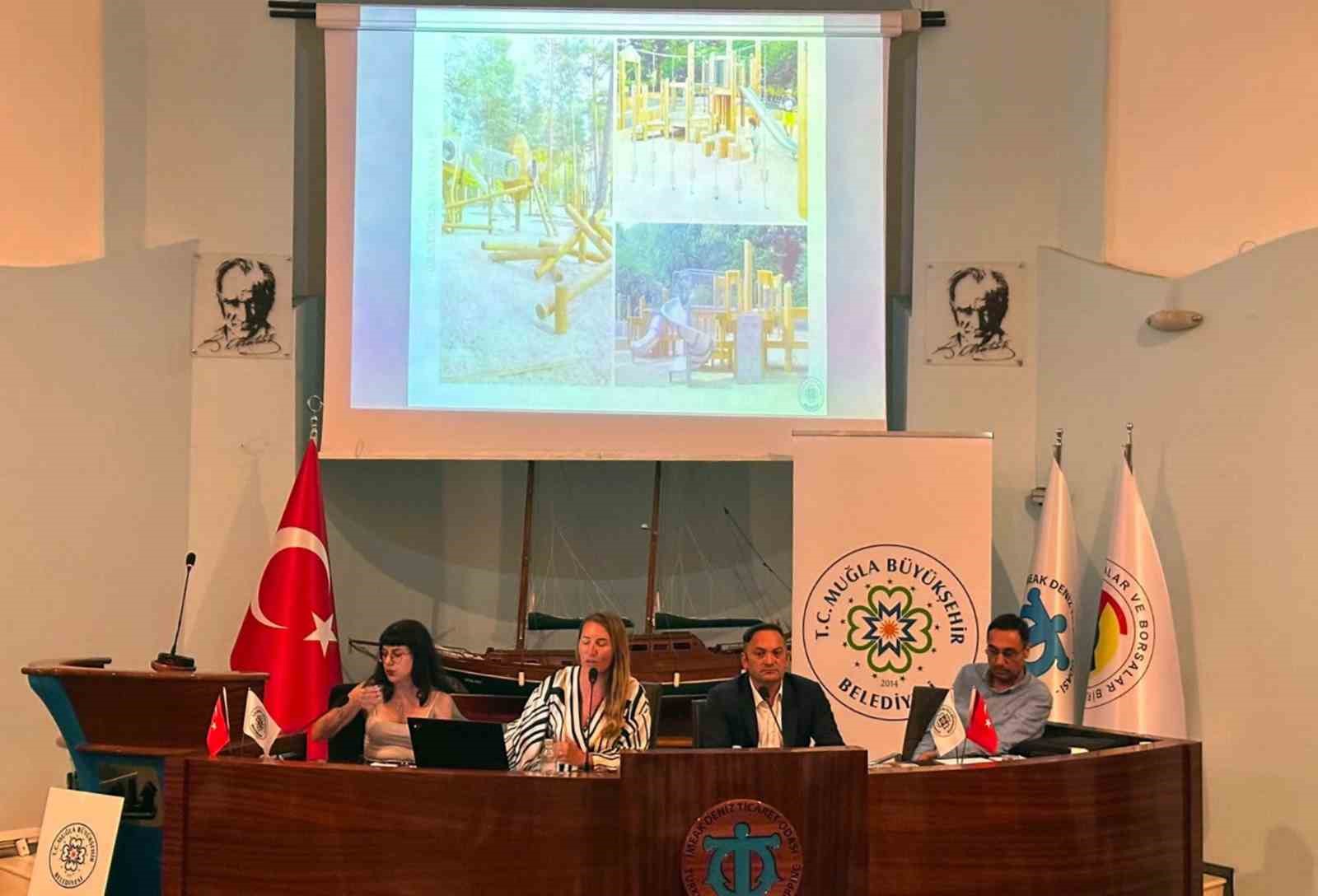 Muğla Büyükşehir Belediyesi proje tanıtım toplantısında sunum yapılan salon ve kürsüdeki yetkililer.
