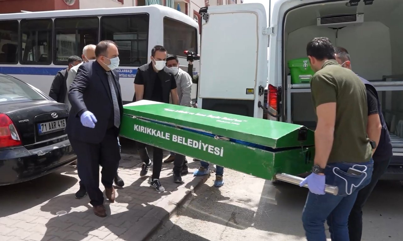 Görevlilerin cenaze aracına tabut taşıdığı olay yeri görüntüsü.