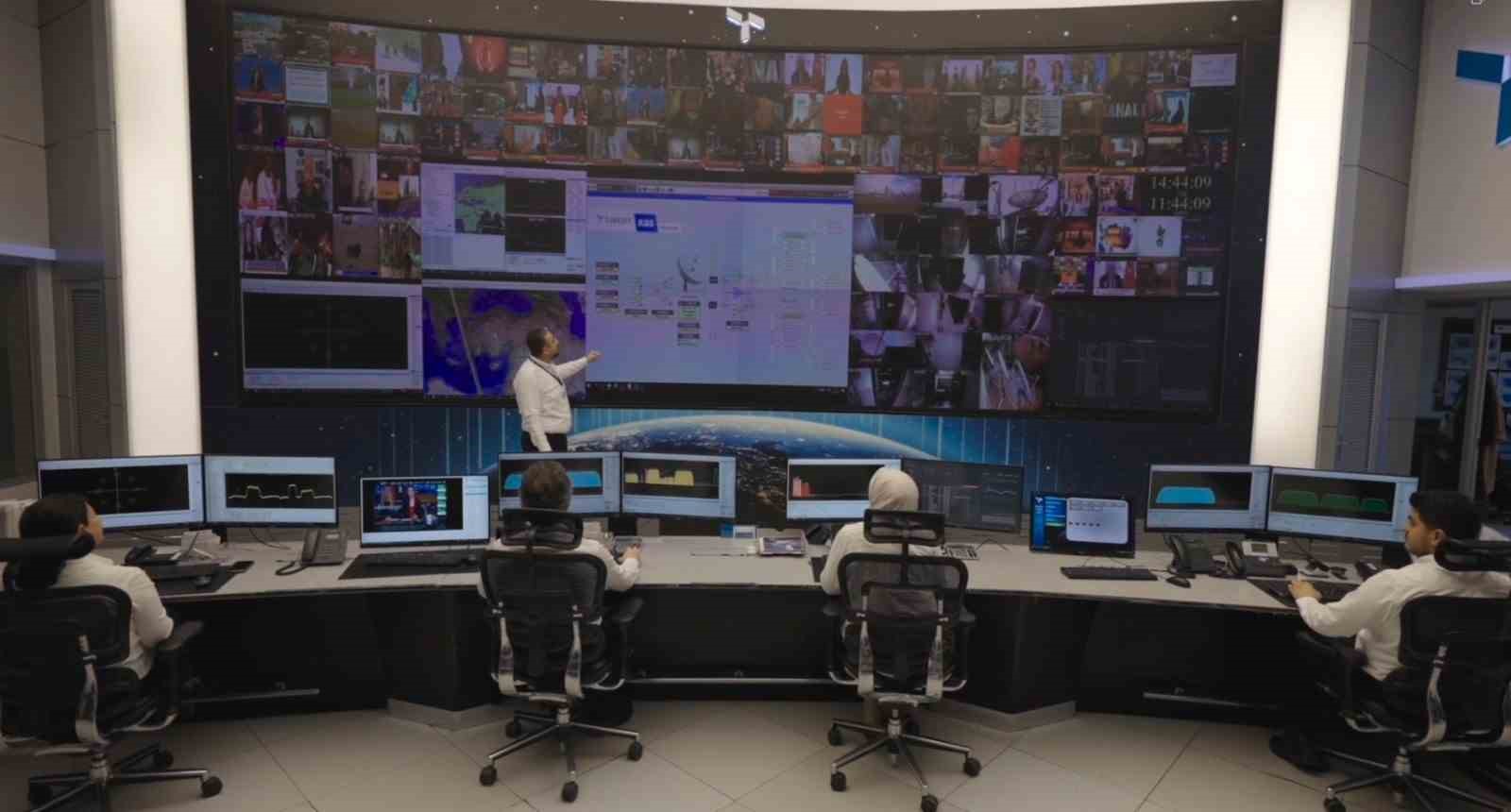 Türksat kontrol merkezinde mühendislerin yayın aktarım sürecini takip ettiği ekranlar görülüyor.