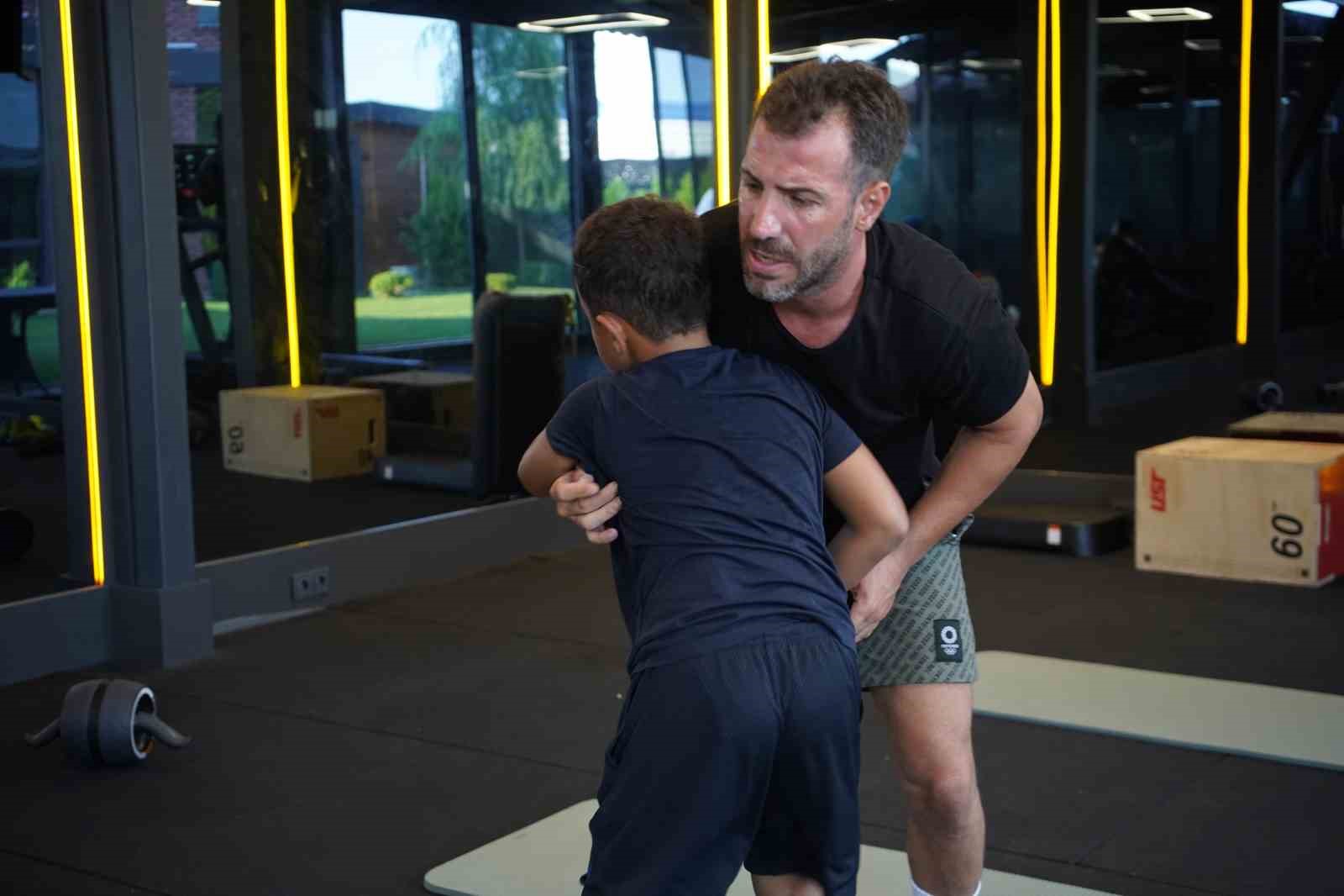 Kürşat Kiraz spor salonunda bir öğrencisine güreş tekniği gösteriyor.
