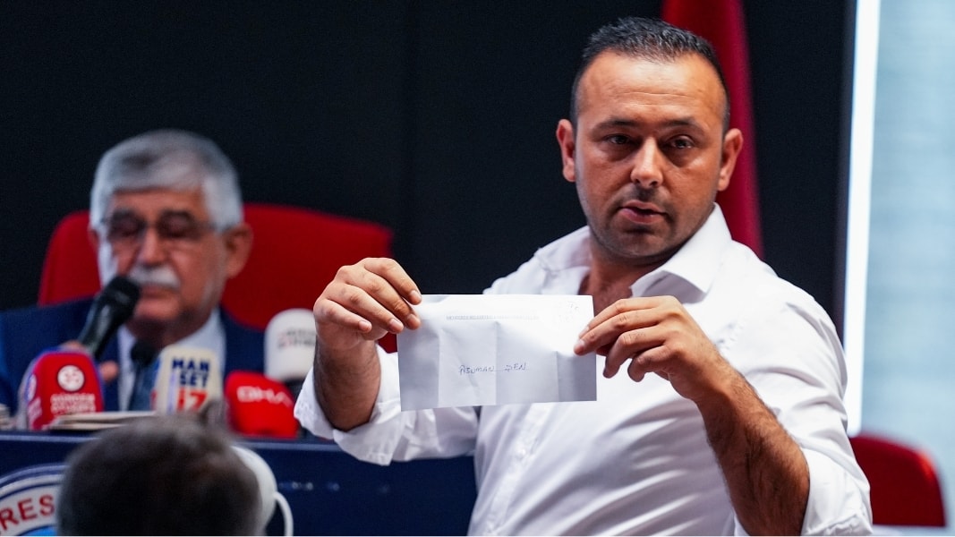 Meclis salonunda bir kişi elindeki zarfı gösterirken basın mensupları görüntü alıyor.