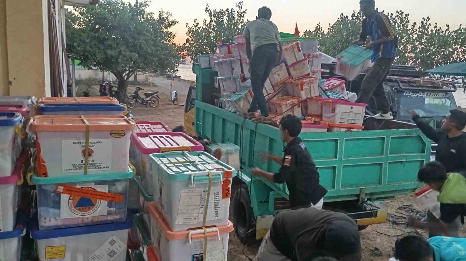 Deprem sonrası yardım kolilerinin bir kamyona yüklendiği çalışma alanı.