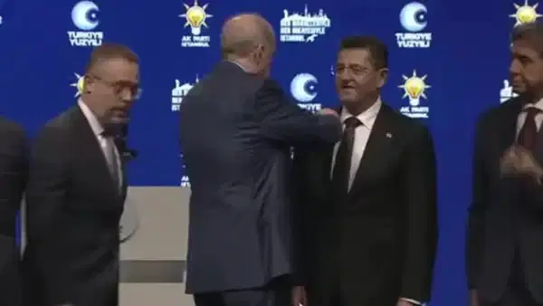 Sahnedeki törende Orhan Çerkez’e rozet takıldığı an.