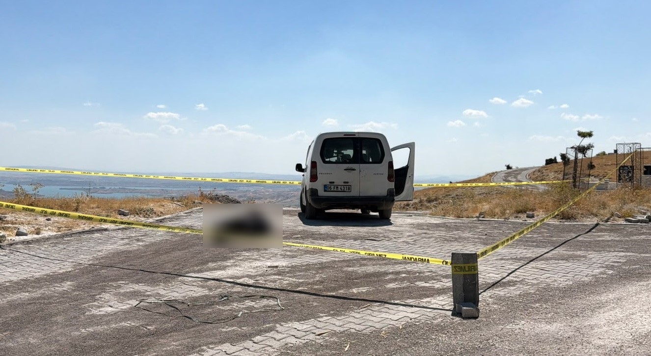 Adıyaman’da mezarlık yakınındaki olay yerinde jandarma güvenlik şeridi ve park halindeki beyaz araç görülüyor.