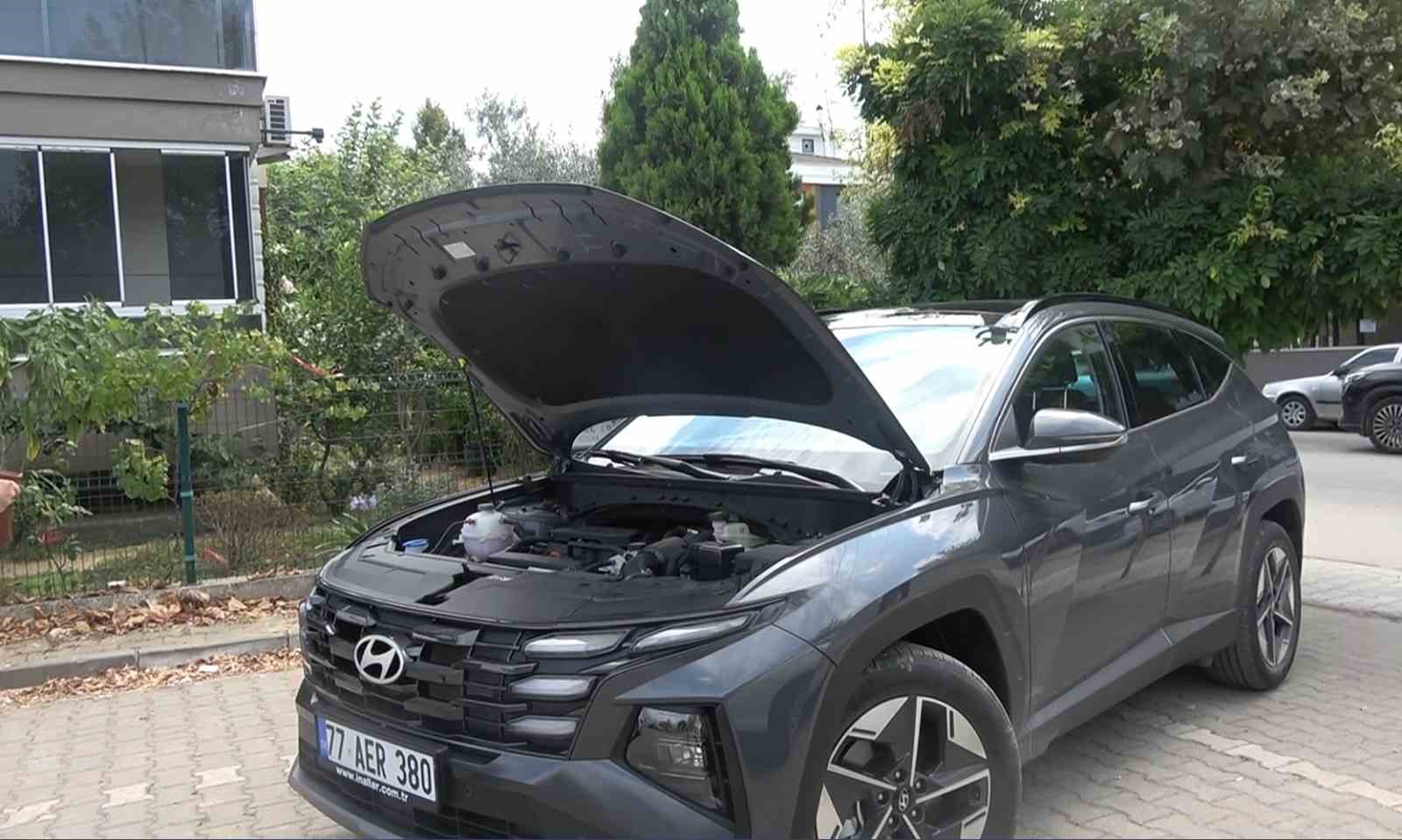 Kaputu açık halde görüntülenen gri Hyundai Tucson.