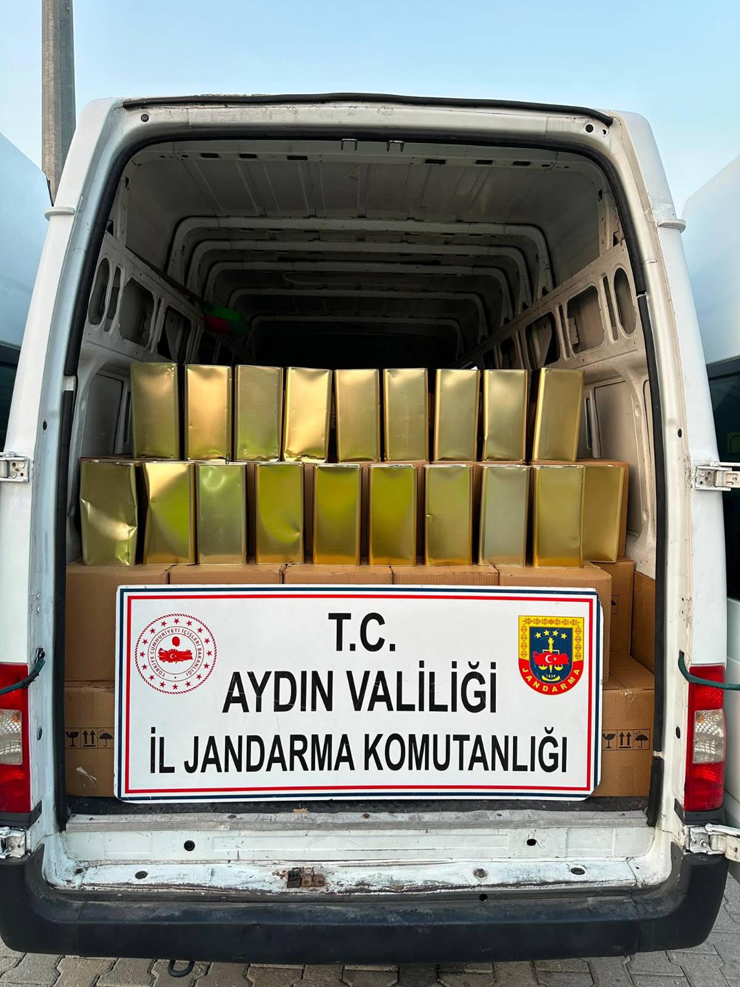 Aydın’da jandarma ekiplerinin durdurduğu kamyonette ele geçirilen tenekeler ve Aydın İl Jandarma Komutanlığı yazılı tabela.