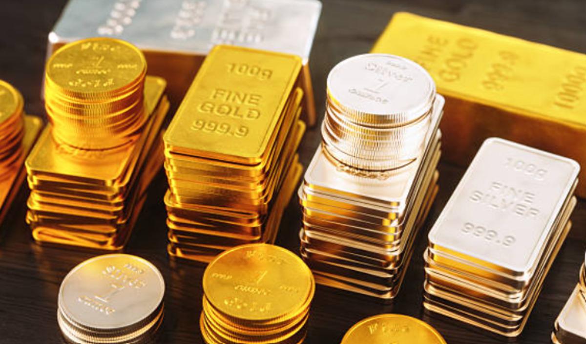 Lingotes de oro y plata junto a monedas de oro sobre una mesa.