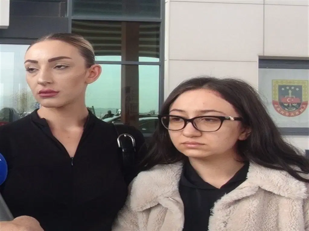 Adliye binası önünde görüntülenen iki kadını gösteren fotoğraf.