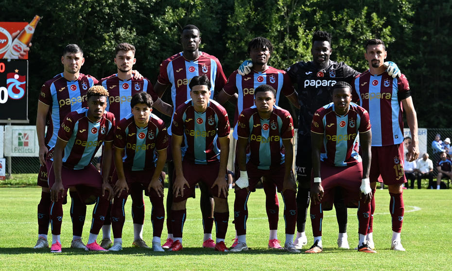 Trabzonspor oyuncuları hazırlık maçı öncesinde takım fotoğrafı için poz veriyor.