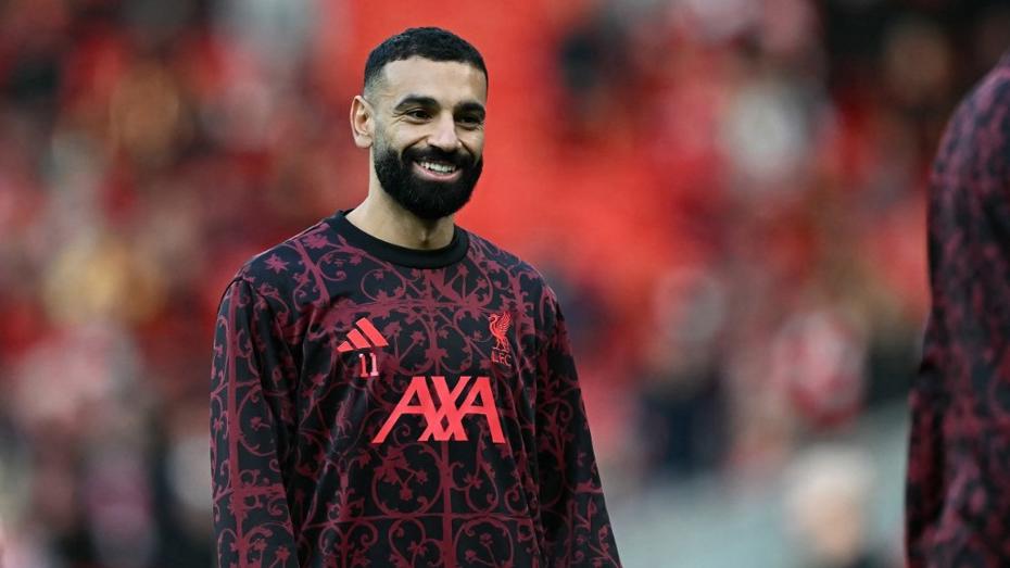 Mohamed Salah antrenman üstüyle saha içinde gülümsüyor.