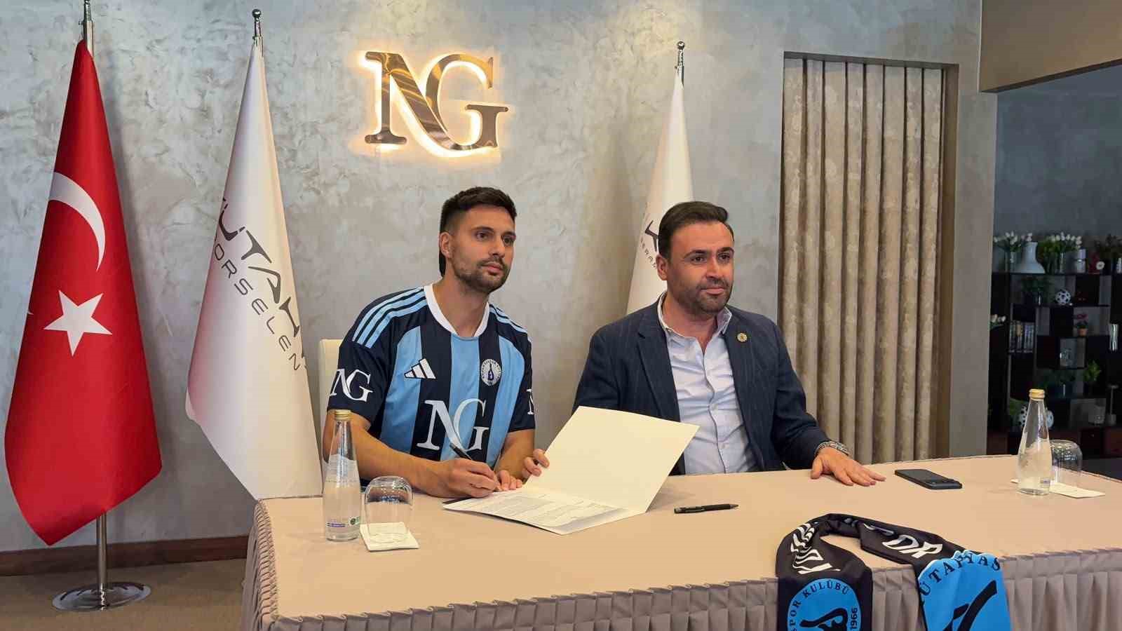 Kütahyaspor forması giyen Tarkan Serbest, kulüp yetkilisiyle birlikte imza töreninde görülüyor.