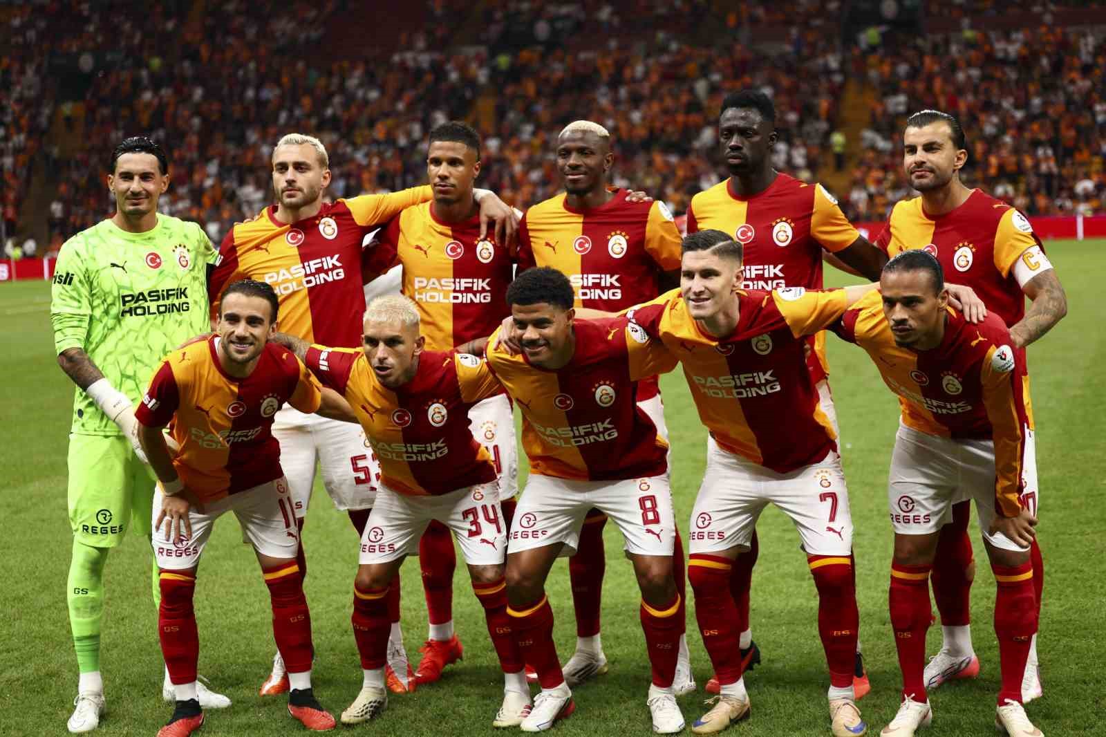 Galatasaray futbol takımı maç öncesi sahada takım fotoğrafı için poz veriyor.