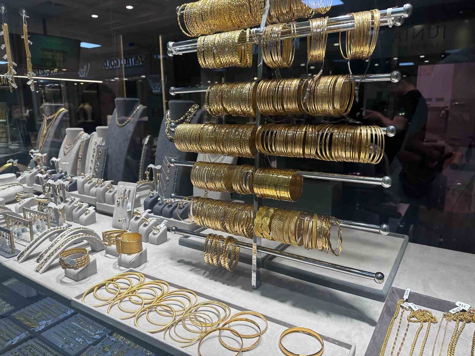 Kuyumcu vitrininde sergilenen bilezikler, kolyeler ve altın takılar.